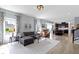 Open-concept living room features hardwood floors, gray sofa, and seamless flow to the kitchen at 13485 Mancroft Dr, Fishers, IN 46037
