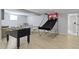 Basement recreation room with foosball table, basketball game, and light wood flooring at 13485 Mancroft Dr, Fishers, IN 46037
