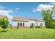 Expansive backyard with a well-manicured lawn, patio set, and view of the home's architecture at 14458 Carlow Run, Carmel, IN 46074