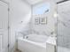 Bright bathroom with a soaking tub, marble surround, and a window for natural light at 14458 Carlow Run, Carmel, IN 46074