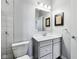 Well-lit bathroom with gray vanity, framed mirror, and a view into the shower area at 14458 Carlow Run, Carmel, IN 46074