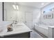 Bright bathroom with a double vanity, marble countertops, soaking tub, and tile flooring at 14458 Carlow Run, Carmel, IN 46074