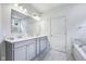 Elegant bathroom with double vanity, gray cabinets, marble countertops, soaking tub, and tile flooring at 14458 Carlow Run, Carmel, IN 46074