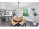 Bright dining area with a wooden table, modern chandelier, and view of kitchen with island at 14458 Carlow Run, Carmel, IN 46074