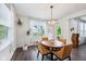 Bright dining area features a wood table and a modern chandelier over dark wood floors at 14458 Carlow Run, Carmel, IN 46074