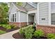 Close-up of a home's exterior featuring brick accents, landscaping, and a well-defined walkway to the front door at 14458 Carlow Run, Carmel, IN 46074