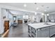 Spacious living room with a fireplace, gray walls, and dark wood floors open to the kitchen at 14458 Carlow Run, Carmel, IN 46074