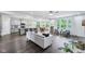 Open-concept living room with a view of the kitchen, dining area and dark wood floors at 14458 Carlow Run, Carmel, IN 46074