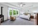 Bright main bedroom with large windows, a ceiling fan, and a cozy sitting area at 14458 Carlow Run, Carmel, IN 46074