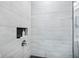 Contemporary shower with large horizontal tiles, black floor, and shower niche at 14458 Carlow Run, Carmel, IN 46074