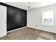 Bright bedroom with a black accent wall, plush carpet, and a stylish modern light fixture at 1454 Silver Pine Ln, Sheridan, IN 46069