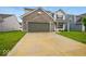 View of home with a brick facade, gray siding, well-maintained lawn, and concrete driveway at 1454 Silver Pine Ln, Sheridan, IN 46069