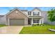 Charming two-story home featuring a brick facade, attached garage, and well-manicured front lawn at 1454 Silver Pine Ln, Sheridan, IN 46069