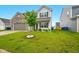 Home's manicured front yard and light gray exterior, complemented by a young, vibrant tree at 1454 Silver Pine Ln, Sheridan, IN 46069