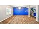 Elegant living room with hardwood floors, bright blue accent wall, and a modern crystal chandelier at 1454 Silver Pine Ln, Sheridan, IN 46069