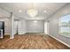 Open-concept living room with light gray walls, hardwood floors, and modern chandelier at 1454 Silver Pine Ln, Sheridan, IN 46069