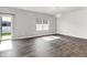 Bright living room featuring hardwood floors, a decorative light fixture, and sliding glass doors to the backyard at 1454 Silver Pine Ln, Sheridan, IN 46069