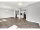 Open-concept living space flows into a modern kitchen, showcasing dark vinyl floors and recessed lighting at 1454 Silver Pine Ln, Sheridan, IN 46069