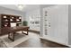 Bright office features a built-in bookshelf, a dark wood desk, with a large window and white entry door at 1454 Silver Pine Ln, Sheridan, IN 46069