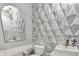 Stylish half bath with geometric wall tiles, modern fixtures, and a unique vanity mirror at 1454 Silver Pine Ln, Sheridan, IN 46069
