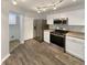 Modern kitchen with stainless steel appliances, white cabinetry, and hardwood floors at 15110 Fawn Hollow Ln, Noblesville, IN 46060