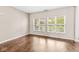 Versatile empty room with gleaming hardwood floors and two bright windows at 15421 Bowie Dr, Westfield, IN 46074