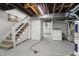 Unfinished basement with stairs, laundry area, exposed ceiling and painted concrete walls at 1720 Woodlawn Ave, Indianapolis, IN 46203