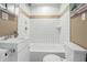 Cozy bathroom featuring tiled walls, a bathtub with shower, and a modern white vanity at 1720 Woodlawn Ave, Indianapolis, IN 46203