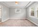 Bright bedroom featuring neutral carpet, gray walls, and modern tray ceiling at 1720 Woodlawn Ave, Indianapolis, IN 46203