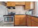 Well-lit kitchen features stainless steel appliances, updated fixtures, and wooden cabinets at 1720 Woodlawn Ave, Indianapolis, IN 46203
