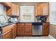 Well-lit kitchen featuring stainless steel appliances, wood cabinets, a sink with modern fixtures and tile floors at 1720 Woodlawn Ave, Indianapolis, IN 46203