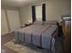 Bedroom with a bed and striped comforter, a window, and closet doors in neutral tones at 1733 E 47Th St, Anderson, IN 46013