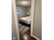 Through a doorway, a cozy bedroom with a comfortable comforter, window, and bedside lamp is shown at 1733 E 47Th St, Anderson, IN 46013