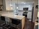 Modern kitchen featuring white cabinets, stainless steel appliances, quartz countertops, and barstool seating at 1733 E 47Th St, Anderson, IN 46013