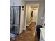View from hallway into the kitchen with stainless steel refrigerator and hardwood floors at 1733 E 47Th St, Anderson, IN 46013