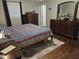 Comfortable bedroom featuring wood floors, a striped comforter, and a dresser with a large mirror at 1733 E 47Th St, Anderson, IN 46013
