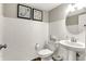 Bathroom with a white pedestal sink and tile walls complemented by elegant decor, offering a clean and stylish space at 17721 Remy Rd, Noblesville, IN 46062