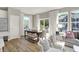 Elegant dining area with abundant natural light, hardwood floors, a modern table set, and adjacent living space at 17721 Remy Rd, Noblesville, IN 46062