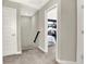Hallway with carpet, gray walls and white trim, featuring a doorway leading to a bedroom at 17721 Remy Rd, Noblesville, IN 46062