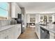 Stylish kitchen featuring white cabinetry, stainless steel appliances, quartz countertops, and views into the dining area at 17721 Remy Rd, Noblesville, IN 46062