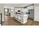 Spacious kitchen boasts white cabinetry, stainless steel appliances, a center island with seating, and hardwood floors at 17721 Remy Rd, Noblesville, IN 46062