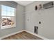 Practical laundry area showcasing a window and space-saving wire shelf with decorative jars at 17721 Remy Rd, Noblesville, IN 46062