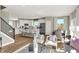 Spacious living room featuring hardwood floors, white cabinets, and views of the kitchen, dining room, and staircase at 17721 Remy Rd, Noblesville, IN 46062