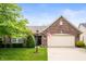 Charming brick home featuring a two-car garage, well-manicured lawn, and an American flag at 18913 Course View Rd, Noblesville, IN 46060
