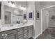 Bathroom featuring double sinks, gray cabinetry, and a view to the walk-in closet at 19390 Mcbee Ave, Westfield, IN 46074