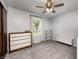 Clean bedroom with large window, wood dresser, neutral tones, and modern ceiling fan at 203 Leerkamp Dr, Franklin, IN 46131