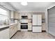 Well-lit kitchen with white appliances, wood flooring, and beige cabinets, providing a clean aesthetic at 203 Leerkamp Dr, Franklin, IN 46131