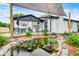 Landscaped backyard featuring a serene pond with aquatic plants, dining area and a charming home at 203 Leerkamp Dr, Franklin, IN 46131