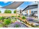 Outdoor patio with pond, lounge chairs, table, and charming landscaping near the black trim white brick house at 203 Leerkamp Dr, Franklin, IN 46131