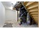 Unfinished basement featuring exposed pipes, stairs, HVAC equipment, and a gray water heater at 2046 N Tibbs Ave, Indianapolis, IN 46222